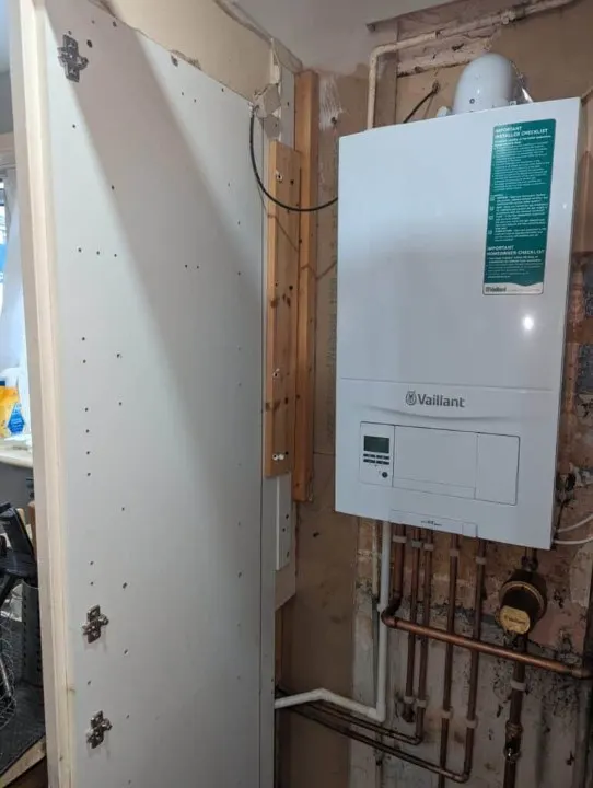 Wall-mounted boiler with copper pipework run neatly beneath it