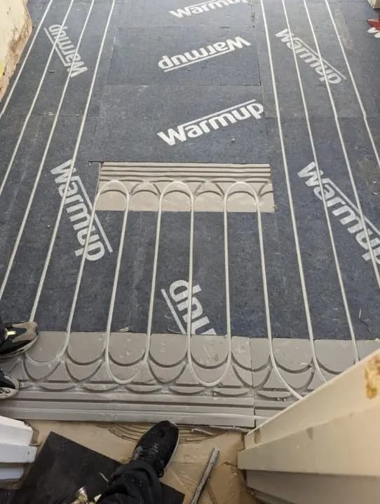 Underfloor heating studded boards laid on a floor before the screed